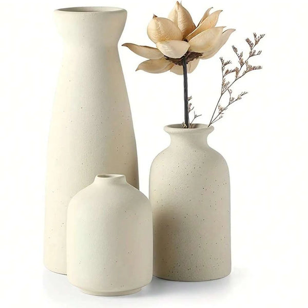 Three ceramic vases styled on a linen dining table